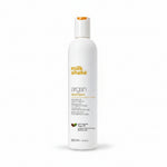 Milk Shake Argan shampoo bottle with argan oil and nuts on a white background