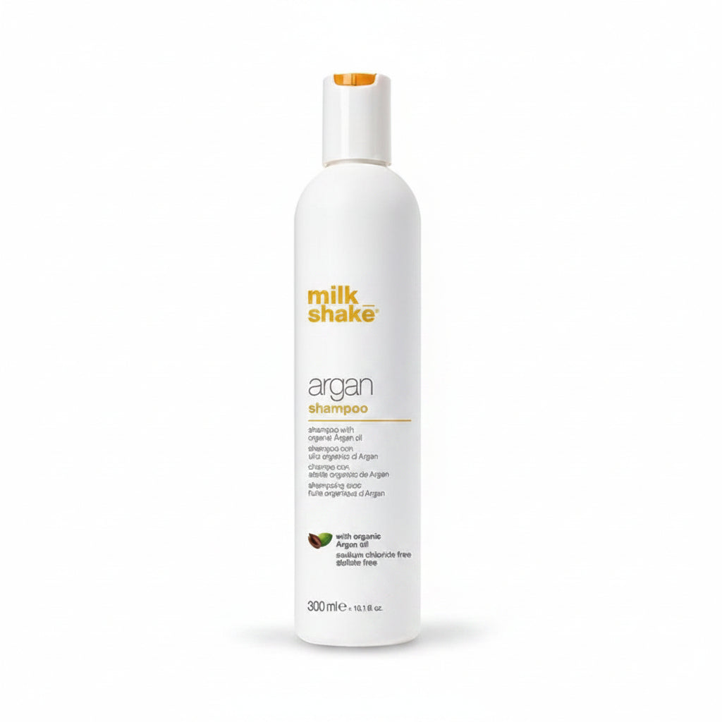 Milk Shake Argan shampoo bottle with argan oil and nuts on a white background