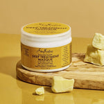 SheaMoisture Deep Treatment Masque jar with shea butter on a wooden board against a yellow background